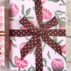 Four wrapped presents with decorative ribbons on a wooden surface