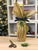gift wrapped bottle in gold tissue with a festive tree and presents in the background